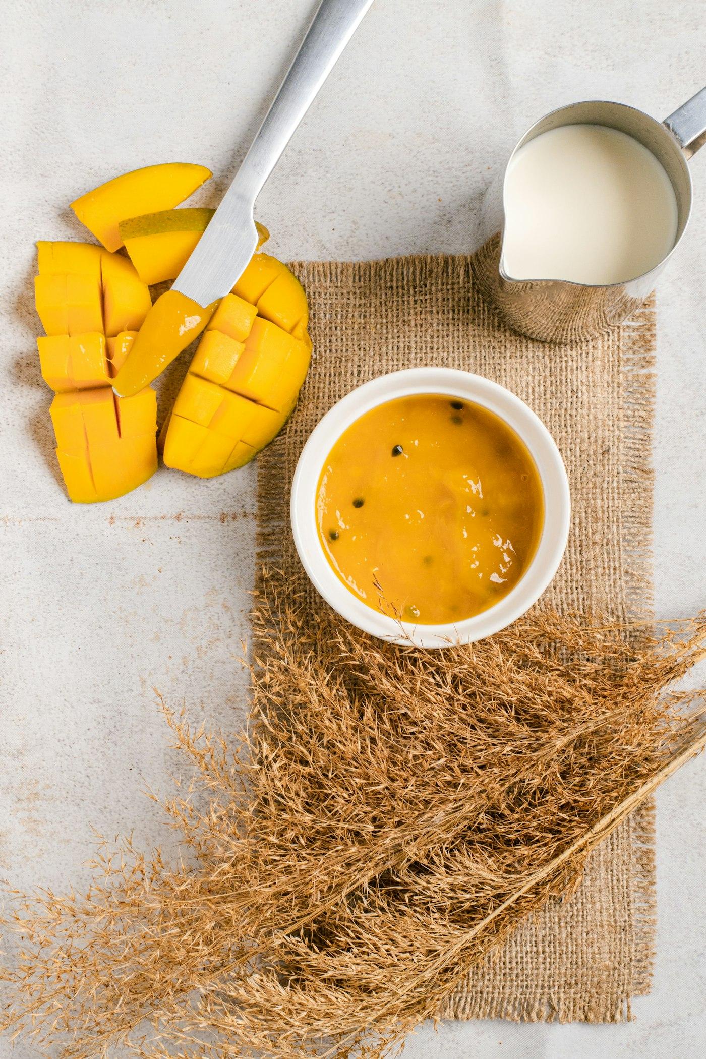 Bowl of fresh mango puree with cut mango