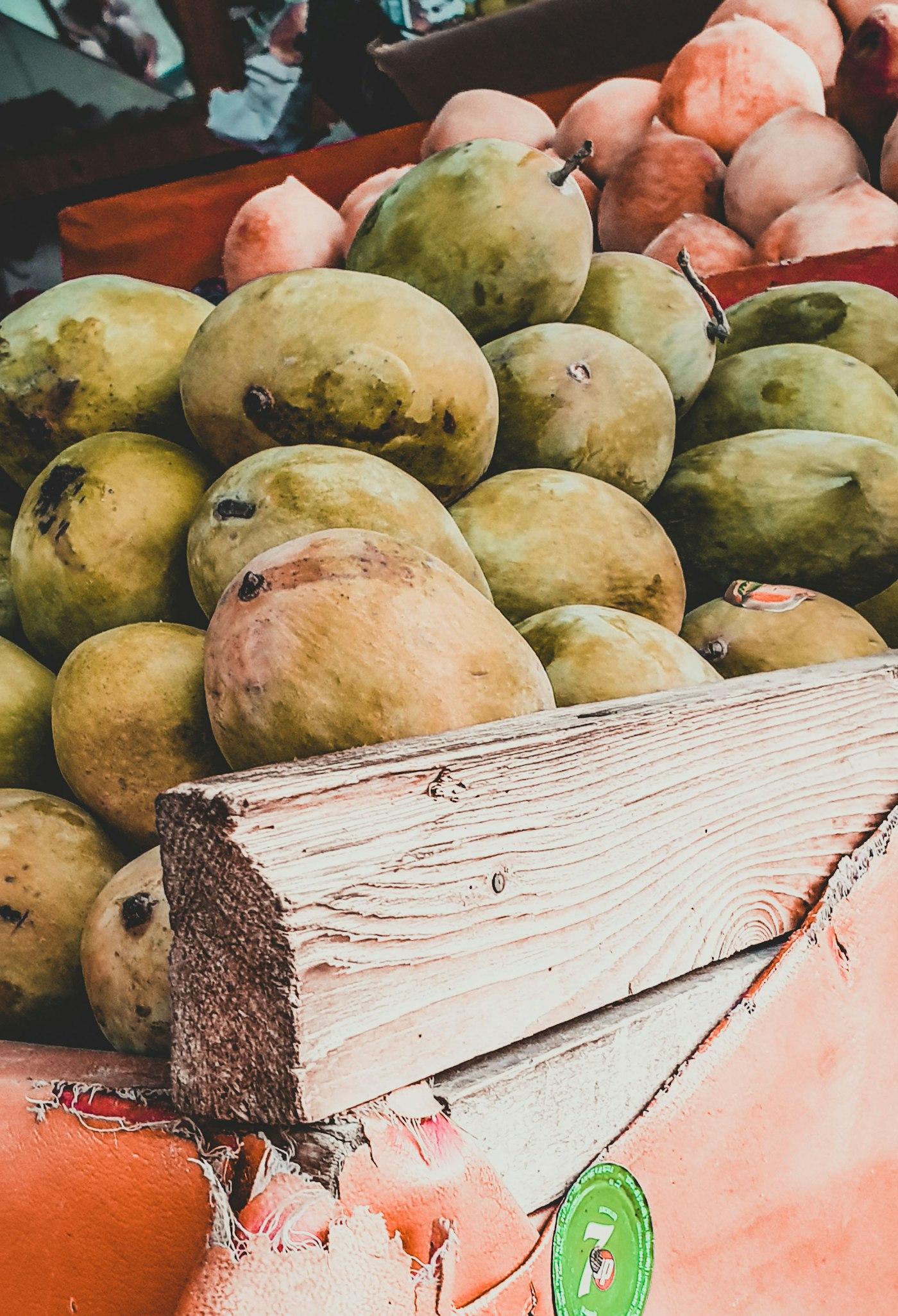 Freshly picked mangoes in a wooden crate